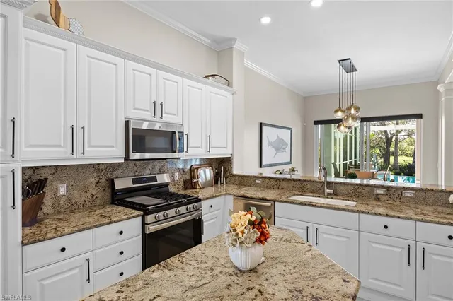 a kitchen with stainless steel appliances granite countertop a sink stove and cabinets