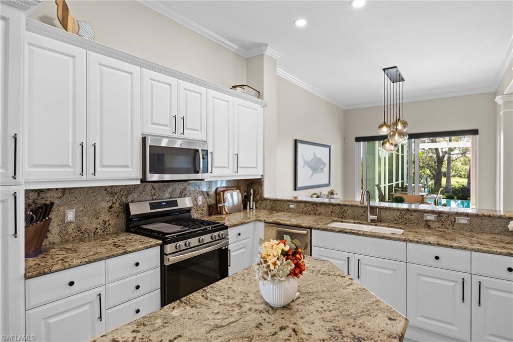 8446 Mallards Way Naples, FL 34114 - Photo 14 of 50 a kitchen with stainless steel appliances granite countertop a sink stove and cabinets