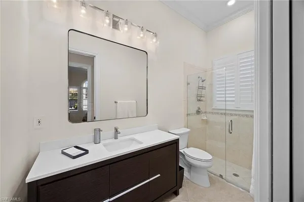 a bathroom with a toilet a sink a mirror and vanity