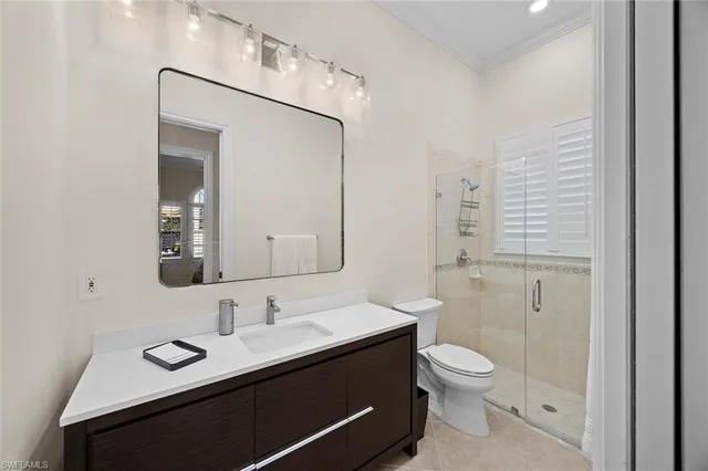 a bathroom with a toilet a sink a mirror and vanity