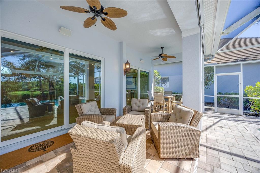 8446 Mallards Way Naples, FL 34114 - Photo 32 of 50 a living room with patio furniture and a floor to ceiling window
