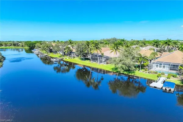 an aerial view of residential houses with outdoor space and ocean view
