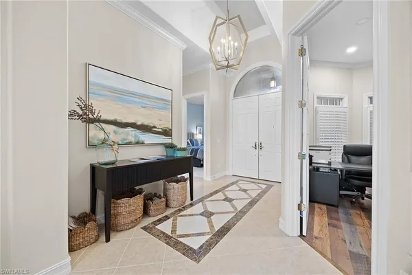 a view of hall way with furniture and chandelier