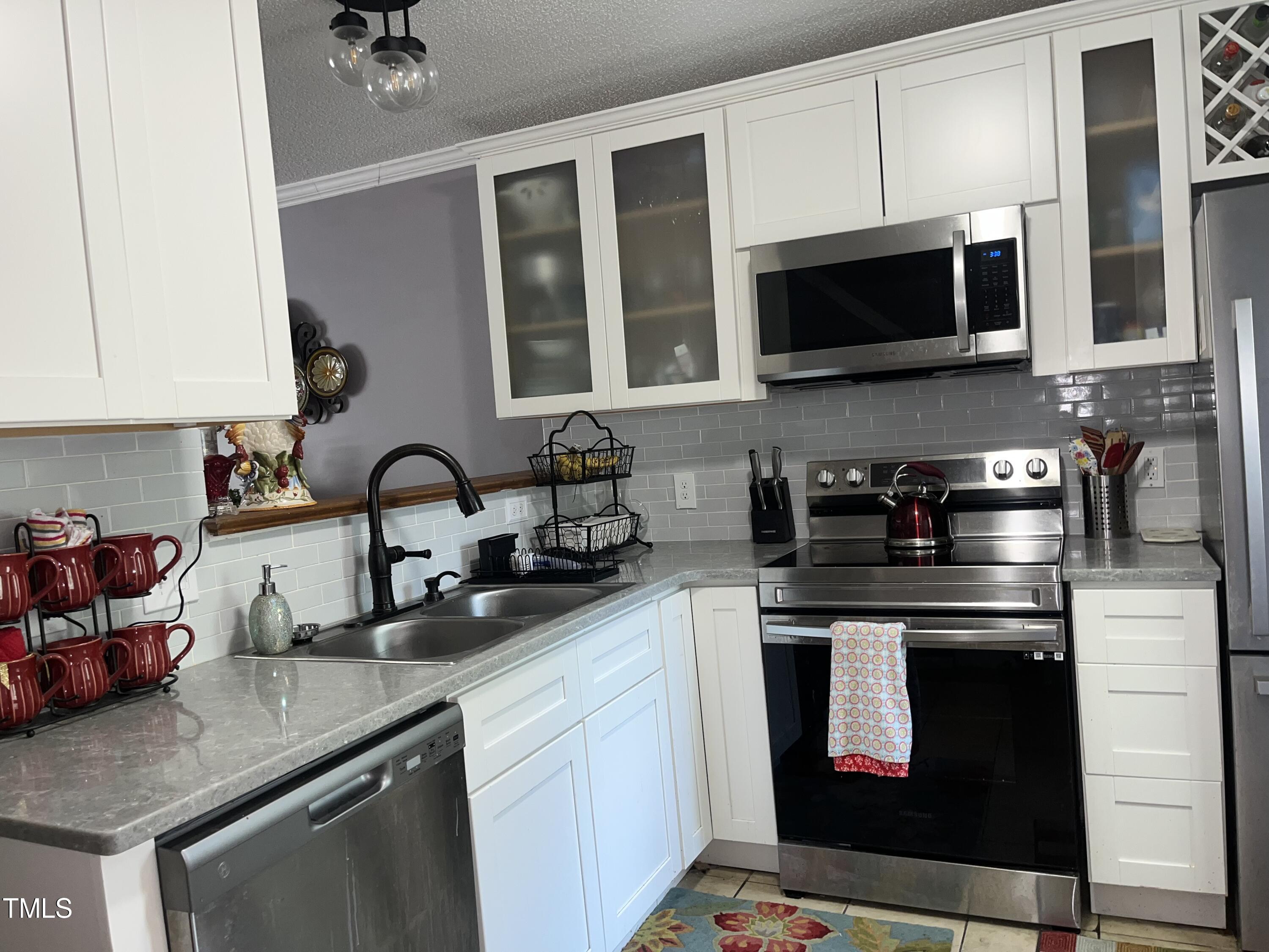 1823 Vintage Road Raleigh, NC 27610 - Photo 5 of 14 a kitchen with stainless steel appliances granite countertop a sink a stove a microwave and cabinets