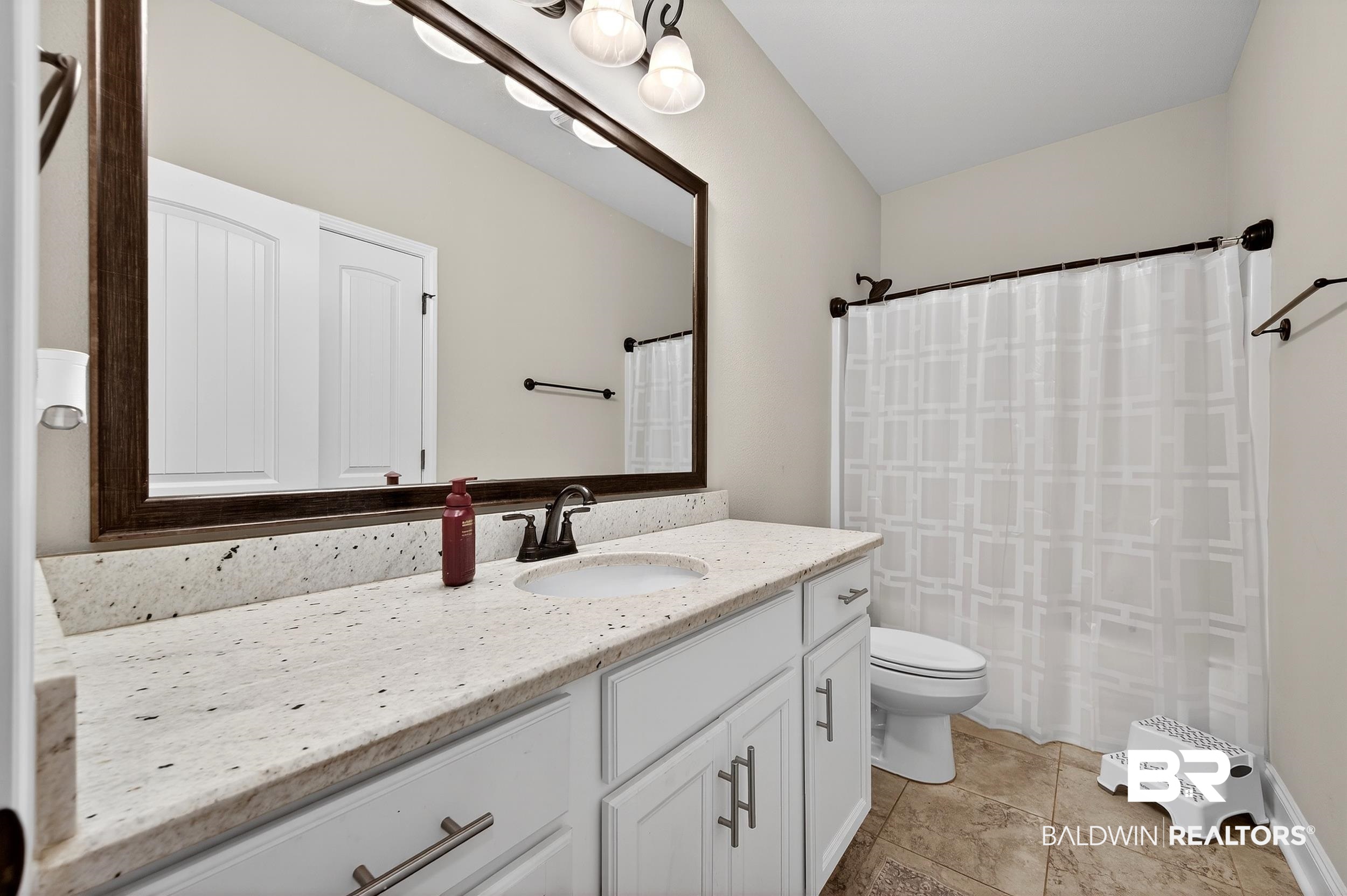 1084 Stella Road Foley, AL 36535 - Photo 25 of 31 Bathroom featuring vanity, curtained shower, and light tile patterned flooring