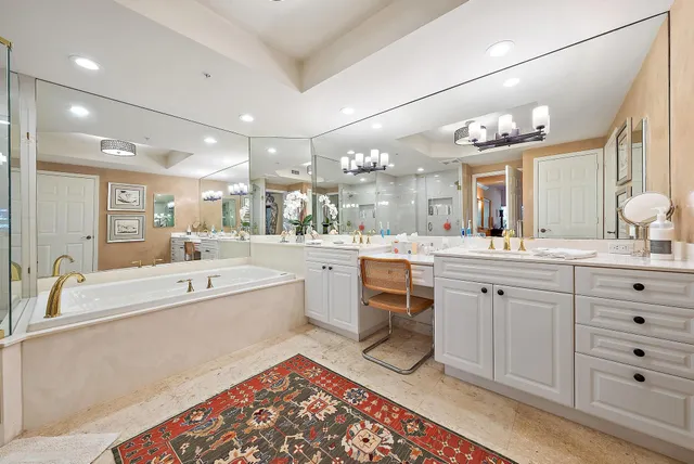 a large bathroom with a large tub sink vanity and granite