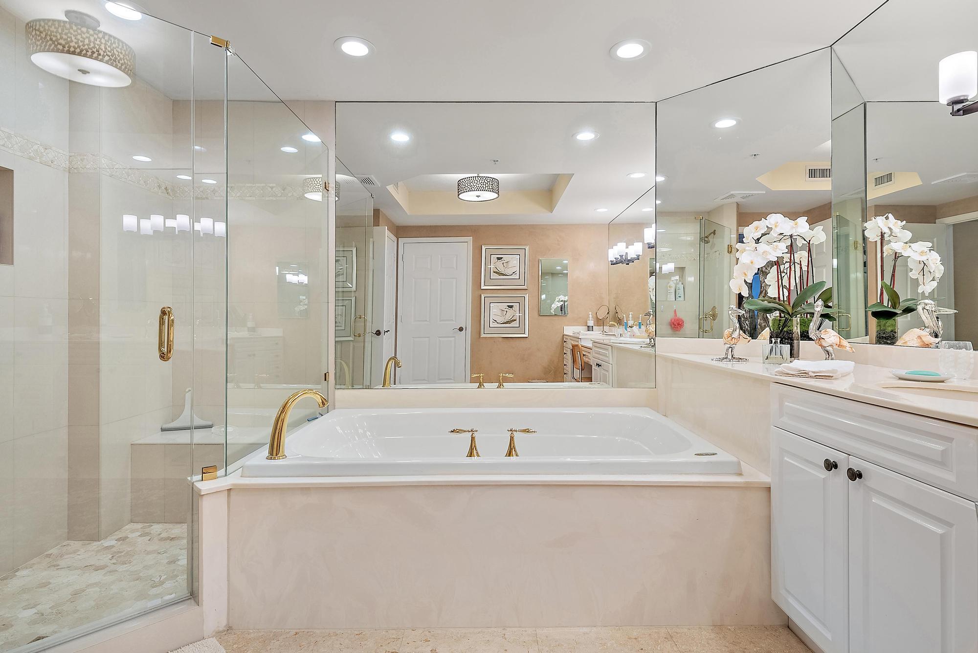 340 Highway 1, Unit 305 Jupiter, FL 33477 - Photo 15 of 26 a bathroom with a tub a sink shower and a mirror