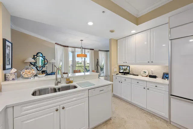 a kitchen with white cabinets and sink