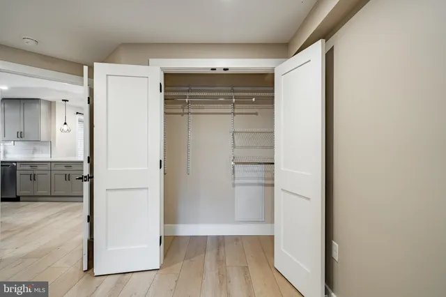 a view of empty room with wooden floor and cabinet