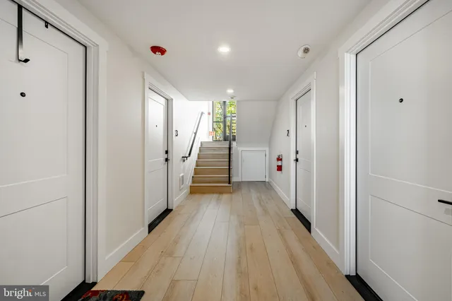 a view of a hallway with wooden floor and staircase