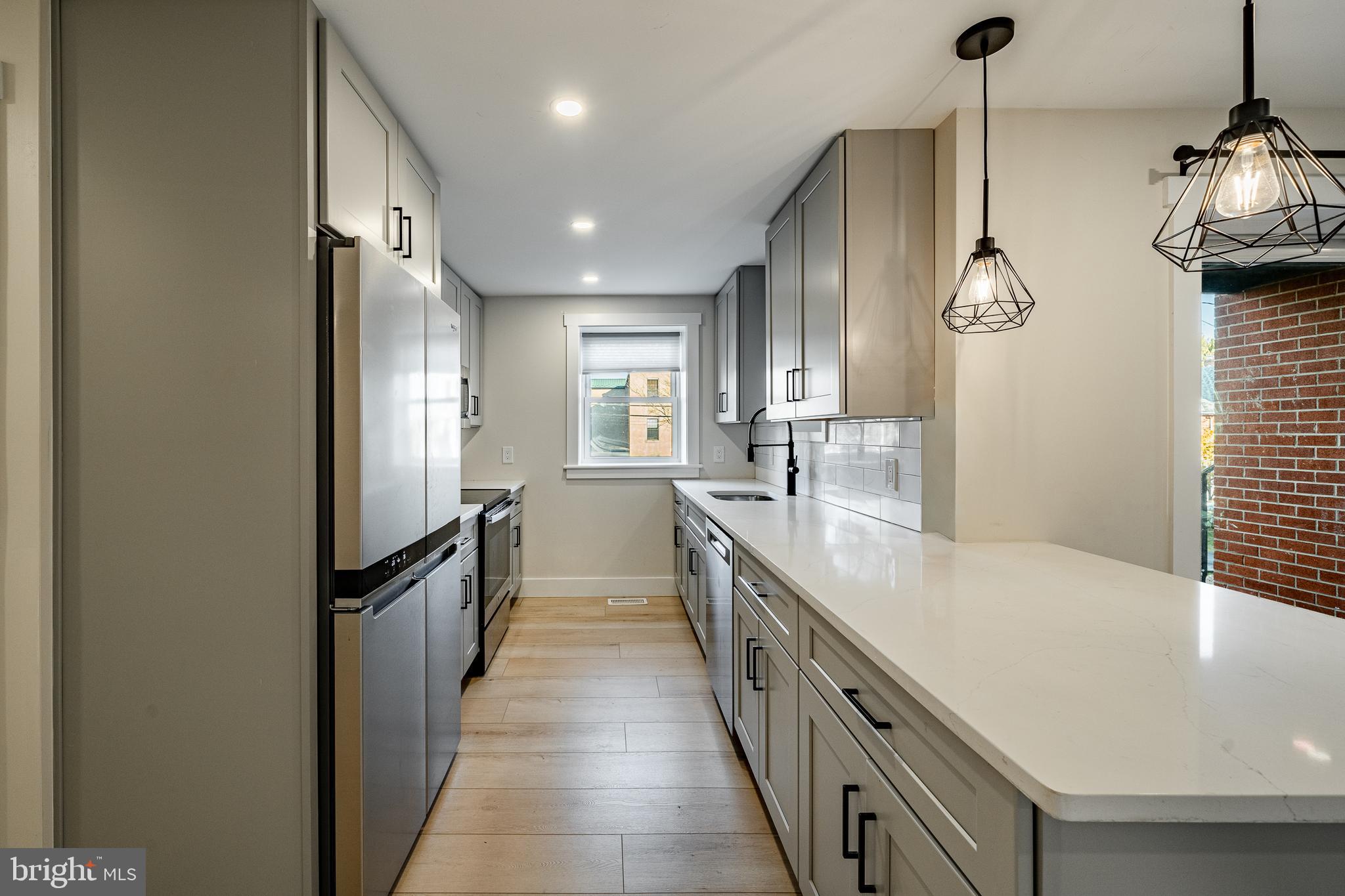 530 Washington Avenue, Unit 4 Phoenixville, PA 19460 - Photo 6 of 28 a large kitchen with granite countertop a lot of counter space and a sink