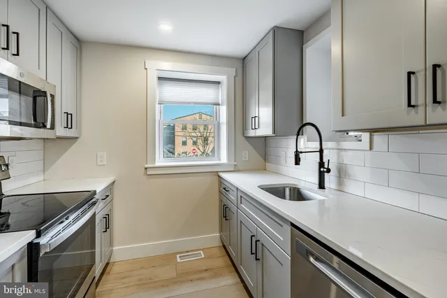 a kitchen with stainless steel appliances granite countertop a sink and a microwave