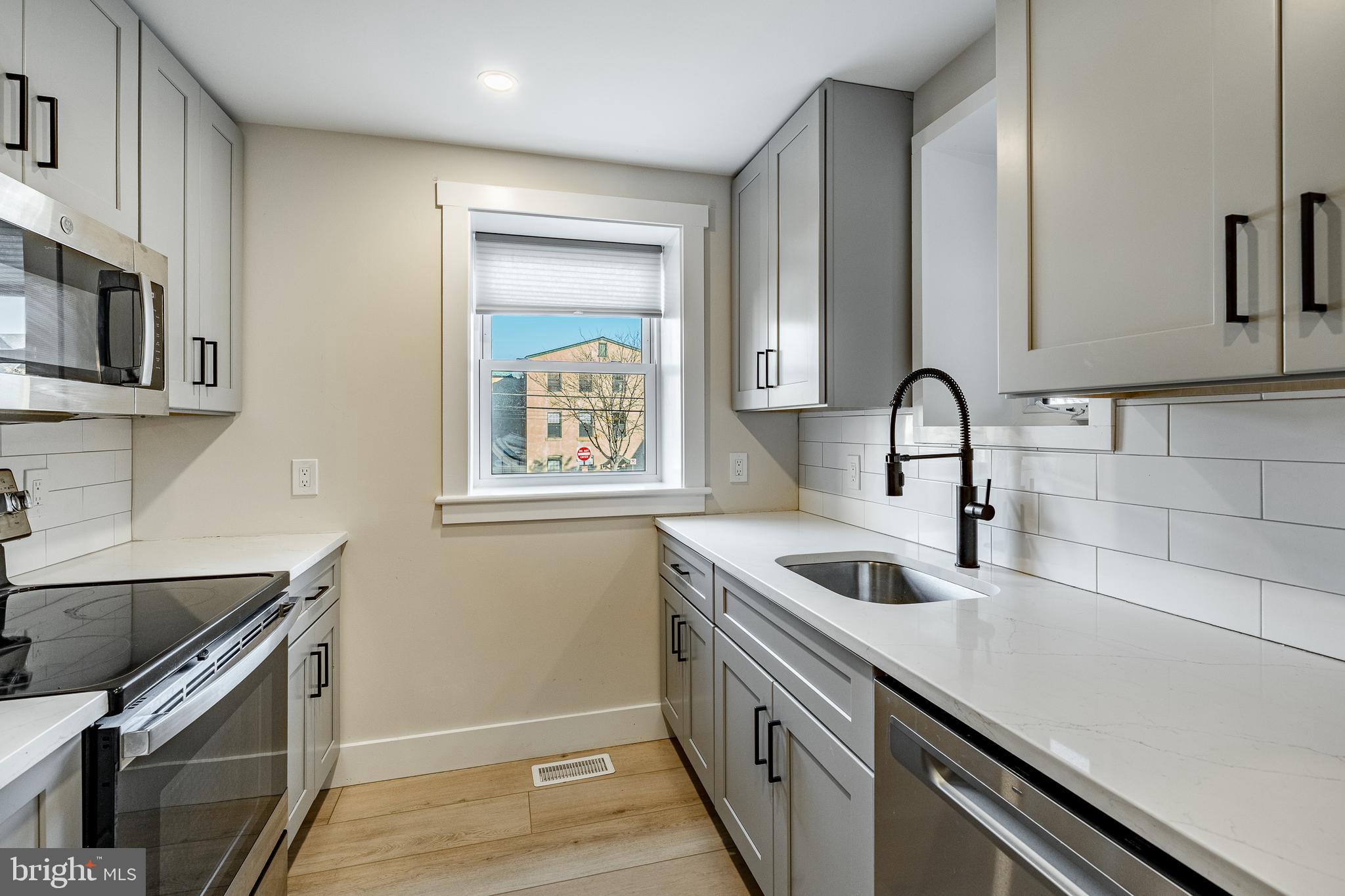 530 Washington Avenue, Unit 4 Phoenixville, PA 19460 - Photo 7 of 28 a kitchen with stainless steel appliances granite countertop a sink and a microwave