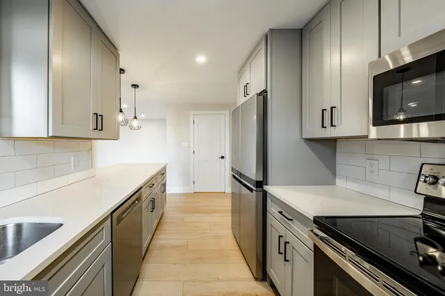 a kitchen with stainless steel appliances a stove microwave and sink