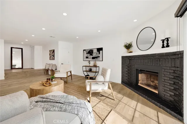 a living room with furniture a fireplace and a potted plant