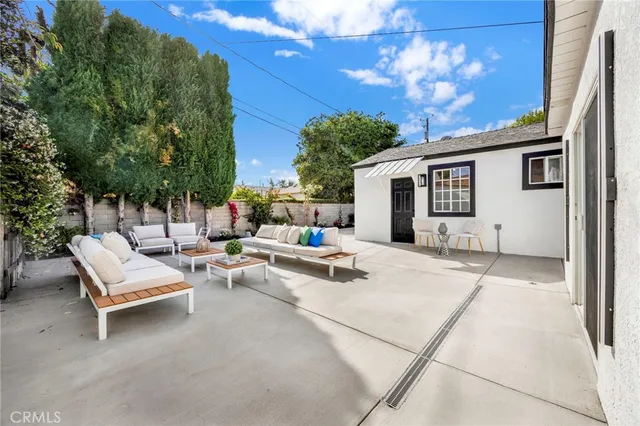 a view of a patio with couches and table and chairs with wooden fence
