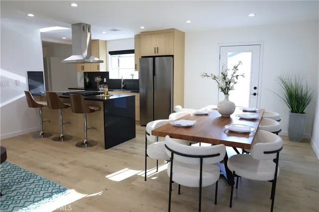 a kitchen with a table chairs refrigerator and microwave