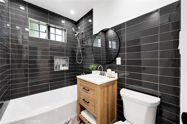a bathroom with a sink toilet vanity and tub