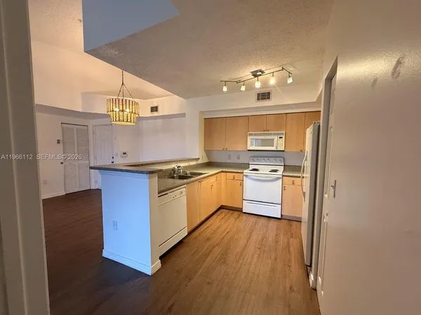 a kitchen with stainless steel appliances granite countertop a stove a sink dishwasher and a refrigerator