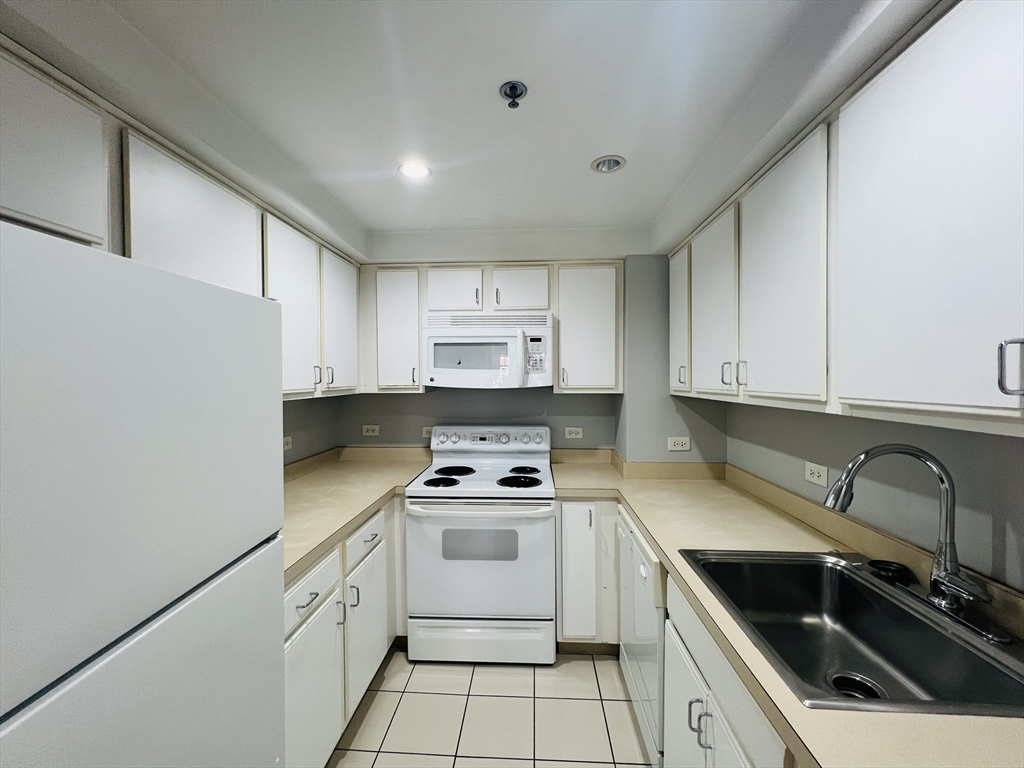 534 Commonwealth Avenue, Unit 3A Boston, MA 02215 - Photo 4 of 15 a kitchen with cabinets appliances a sink and a counter top