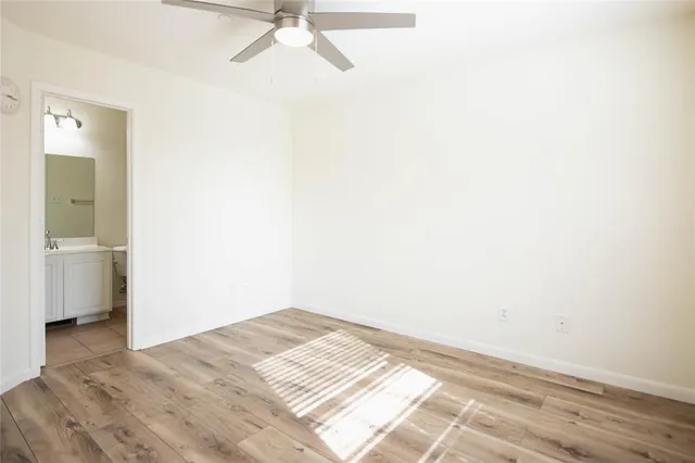 a view of a big room with wooden floor and a bathroom