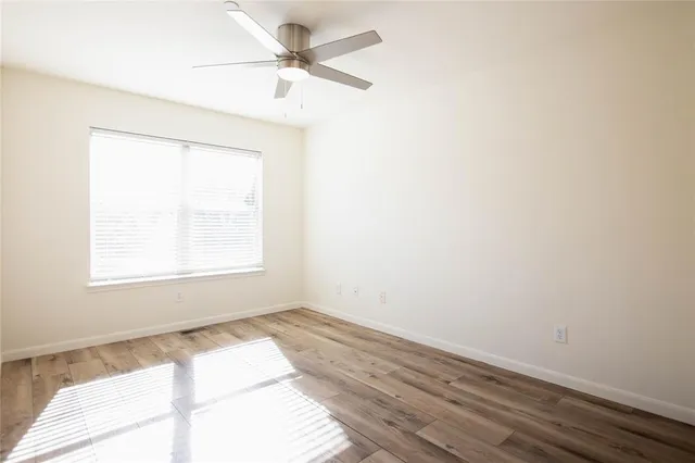 an empty room with a window and a fan