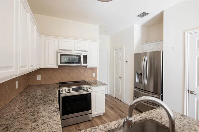 a kitchen with granite countertop a stove and a refrigerator
