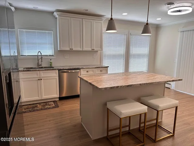 a kitchen with kitchen island a counter space a sink cabinets and appliances