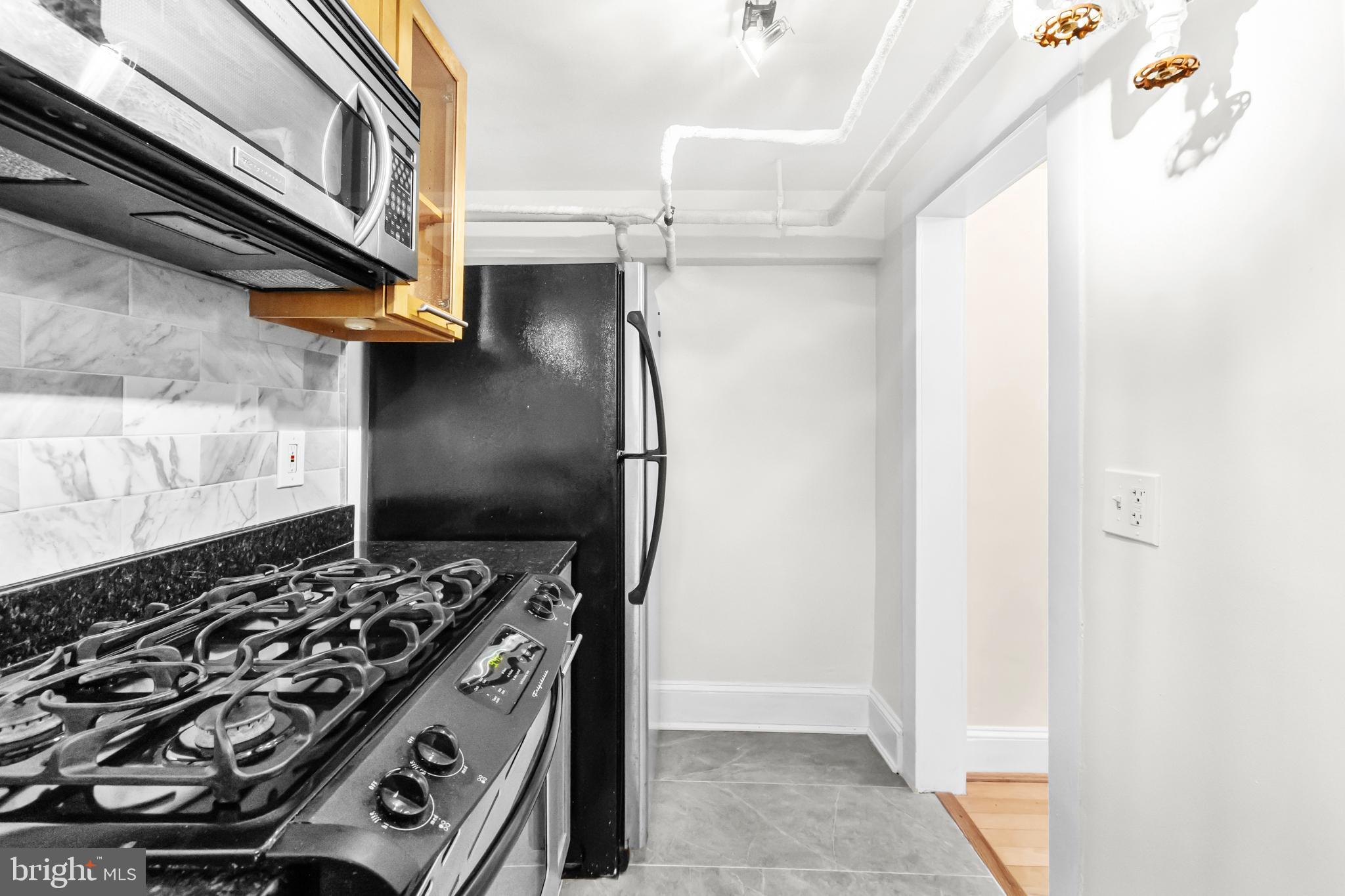 3001 Porter Street Northwest, Unit 100 Washington, DC 20008 - Photo 14 of 22 a kitchen with a stove and a refrigerator