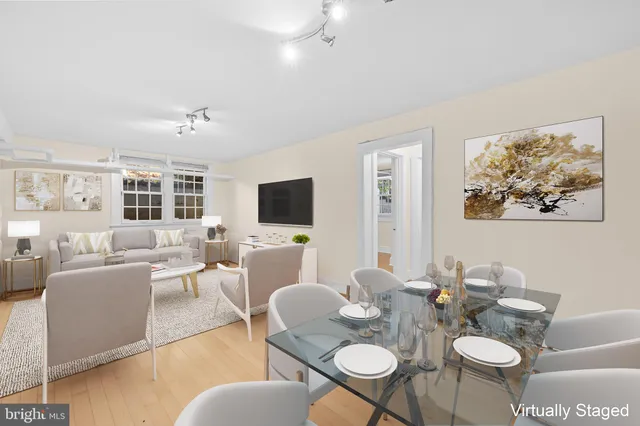 a living room with furniture kitchen view and a flat screen tv