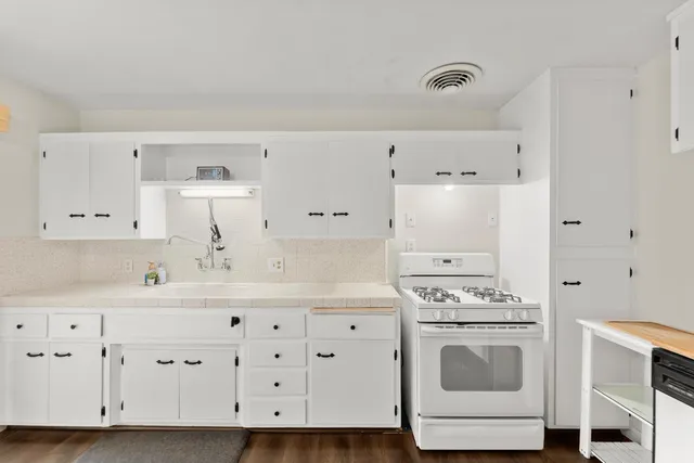 a kitchen with a stove and a white cabinet