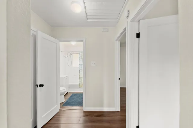 a view of an empty room with window and wooden floor