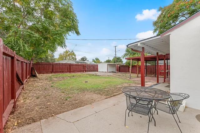 a view of a porch with a table and chairs under an umbrella