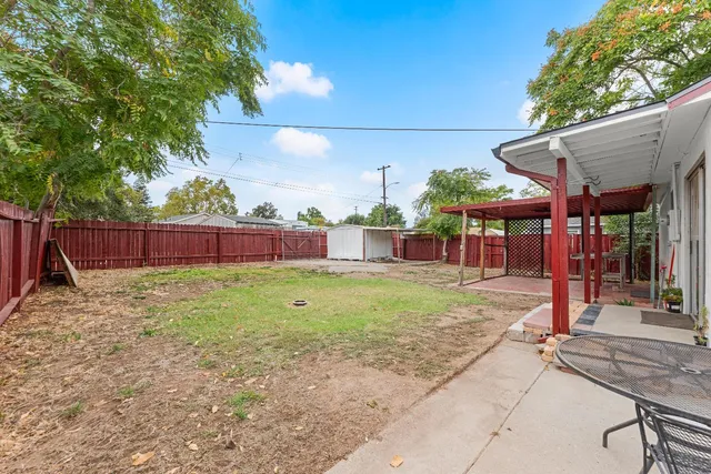 a view of a house with backyard and sitting area