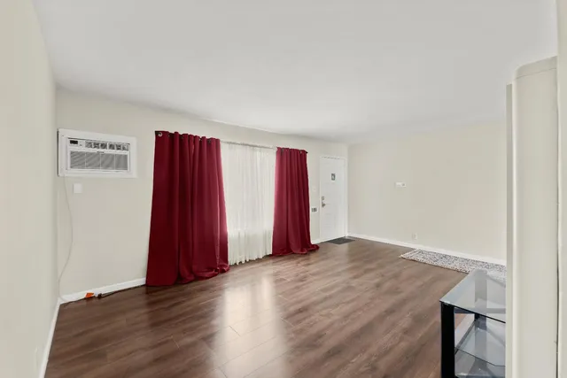 a view of a room with wooden floor and a window