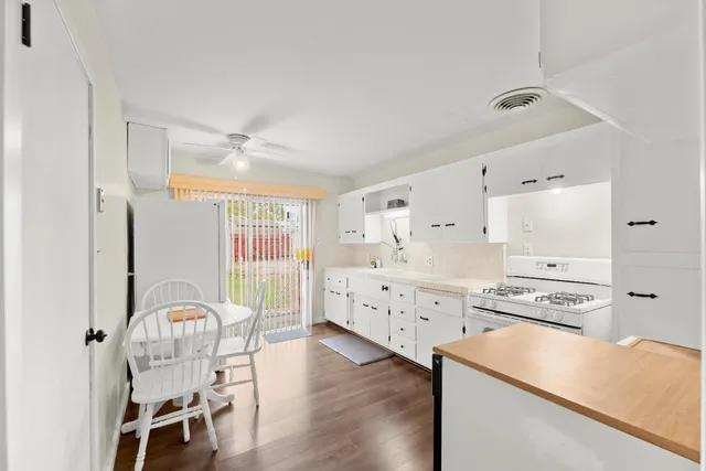 a kitchen with stainless steel appliances a stove a refrigerator cabinets and wooden floor