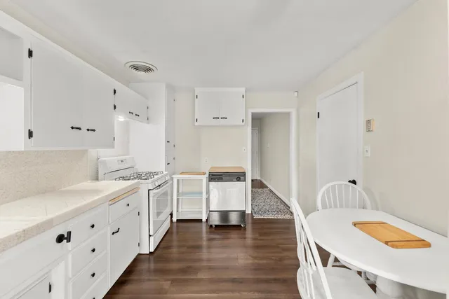 a kitchen with granite countertop white cabinets white stainless steel appliances and sink
