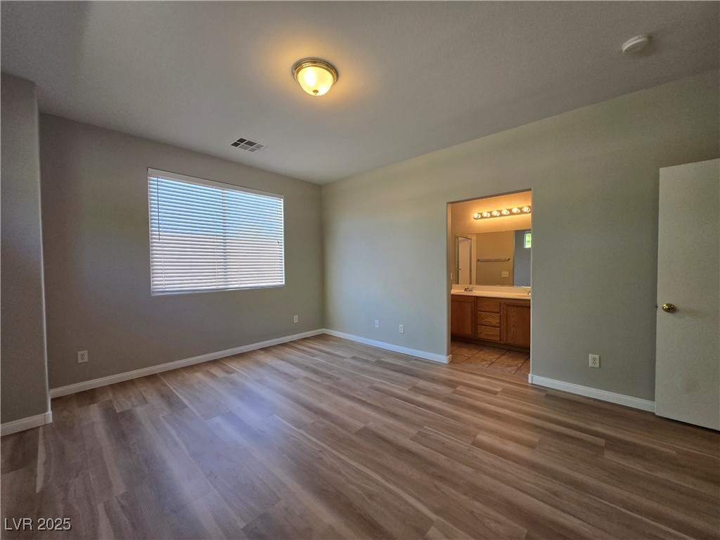 10966 Sutter Hills Avenue Las Vegas, NV 89144 - Photo 15 of 18 Unfurnished bedroom with dark wood-type flooring and ensuite bathroom