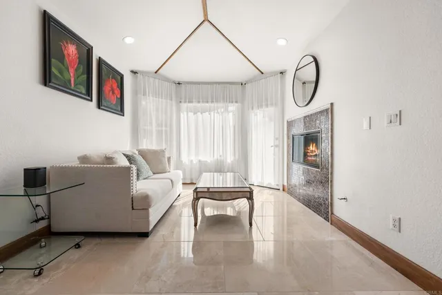 a living room with furniture a flat screen tv and a window