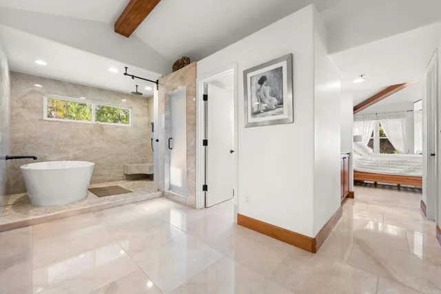 a view of a hallway with bathroom and a shower