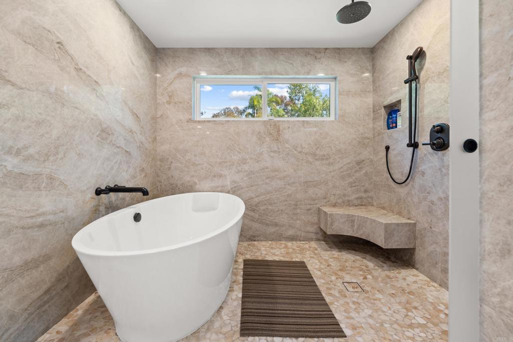 3427 Bumann Road Encinitas, CA 92024 - Photo 22 of 37 a bathroom with a white bath tub a window and a rug
