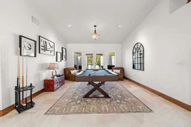 a living room with furniture a rug and wall paintings