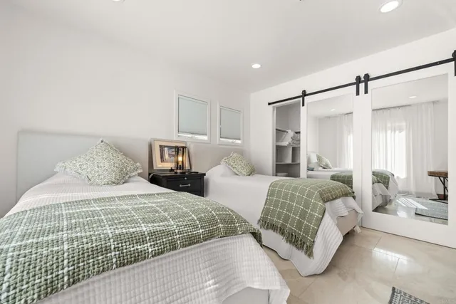 a bedroom with a large bed and a chandelier