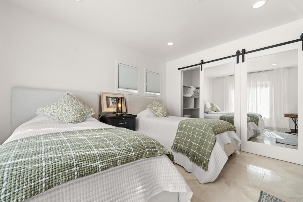 3427 Bumann Road Encinitas, CA 92024 - Photo 34 of 37 a bedroom with a large bed and a chandelier