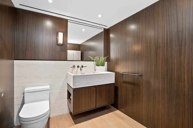 a bathroom with a toilet sink and mirror