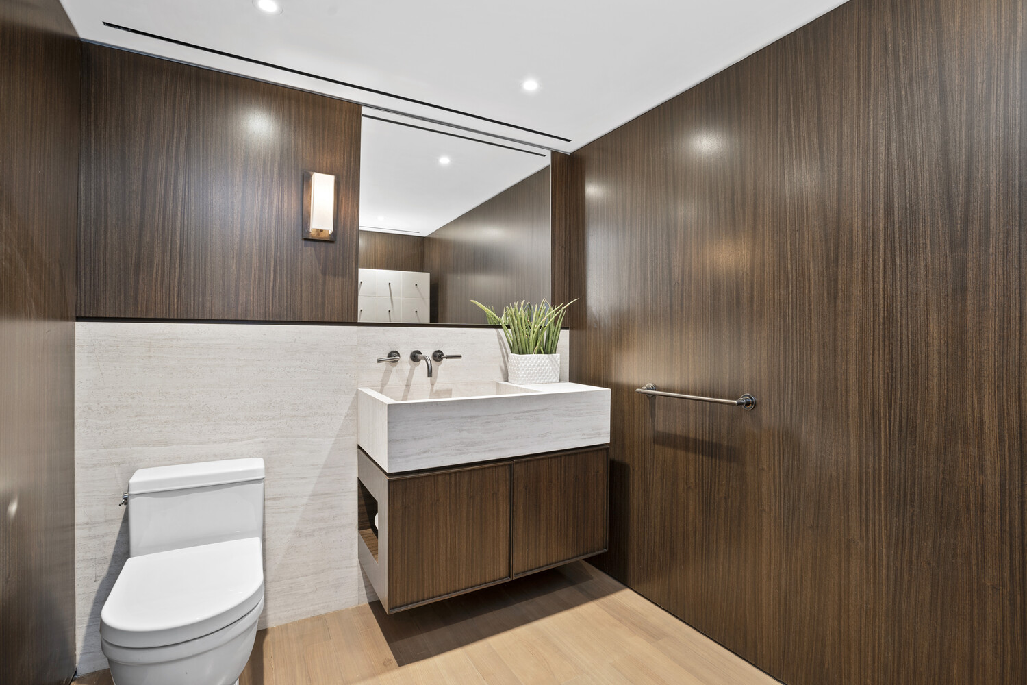 799 Park Avenue, Unit 19BC Manhattan, NY 10021 - Photo 7 of 12 a bathroom with a toilet sink and mirror