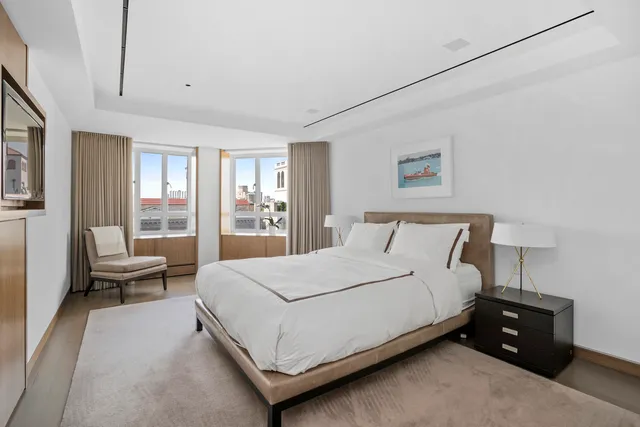 a large bed sitting in a bedroom next to a window