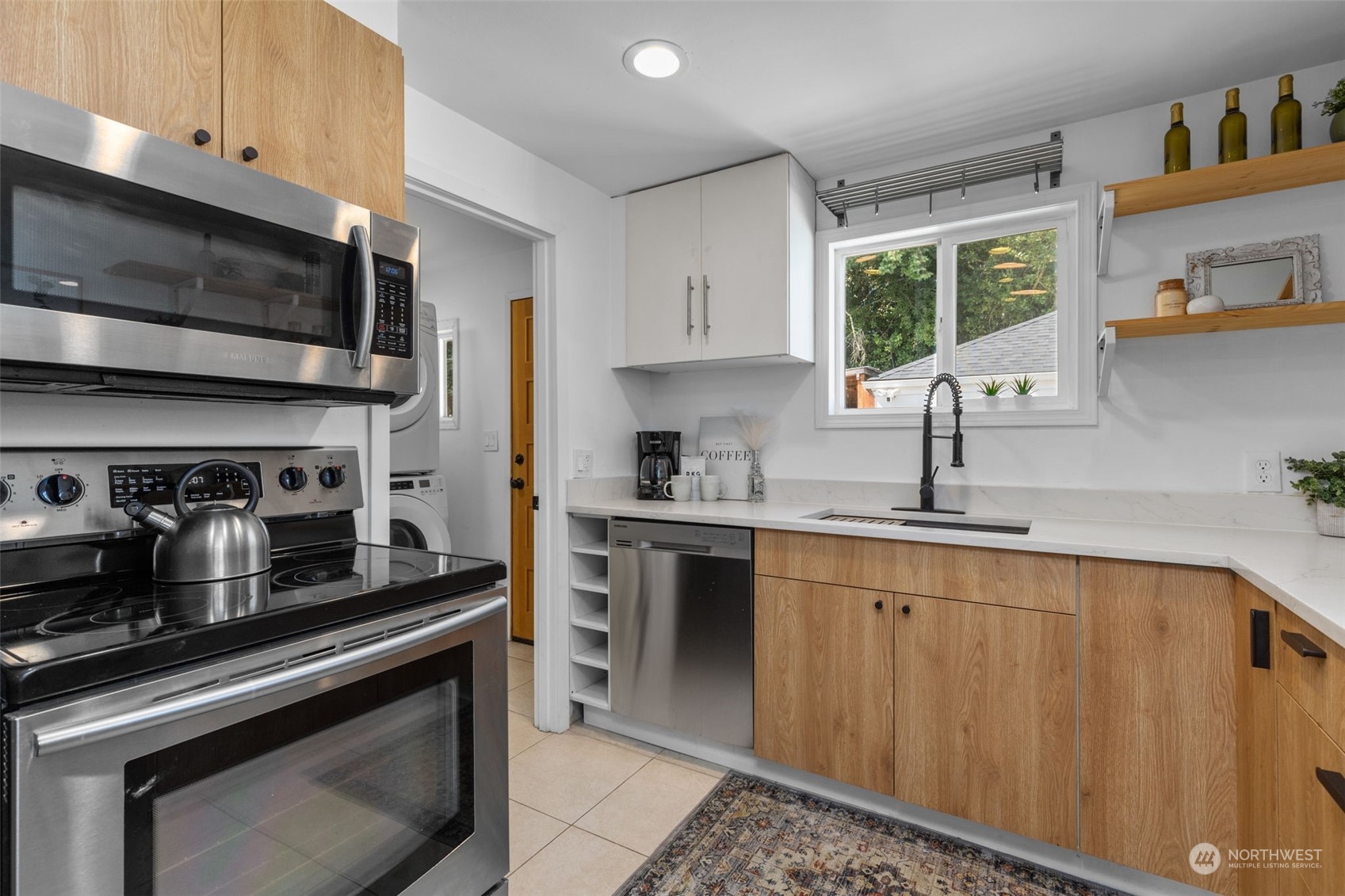 7911 18th Avenue Southwest Seattle, WA 98106 - Photo 10 of 32 a kitchen with stainless steel appliances a stove a sink a microwave and cabinets