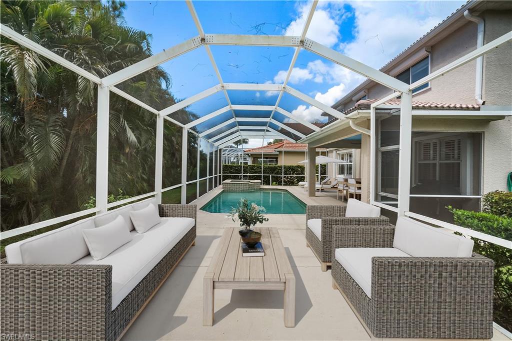5801 Lago Villaggio Way Naples, FL 34104 - Photo 12 of 23 View of swimming pool with a patio, an outdoor hangout area, a pool with connected hot tub, and glass enclosure