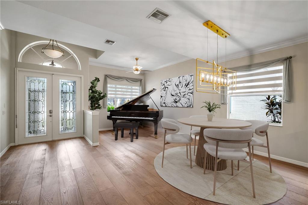 5801 Lago Villaggio Way Naples, FL 34104 - Photo 4 of 23 Foyer entrance with crown molding, light wood finished floors, french doors, and ceiling fan